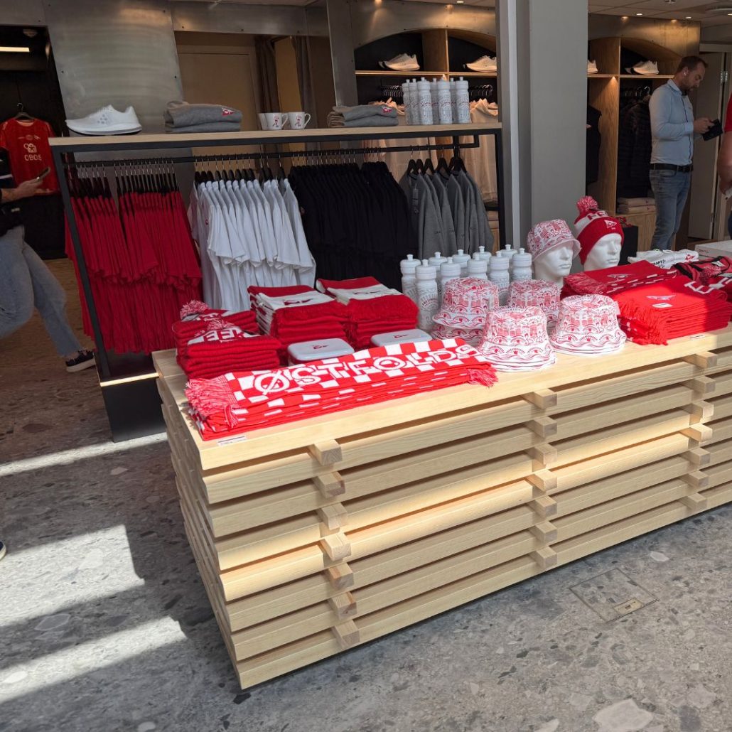 FFK concept store – bordet «Plankehaugen» med supporterartikler foran klesstativ