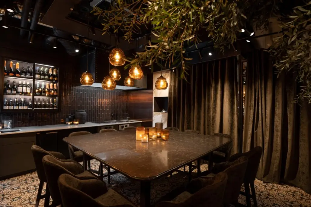 Privat spiseområde på Olivia Ramsalt med stort marmorbord, velurstoler, hengelamper og levende lys.