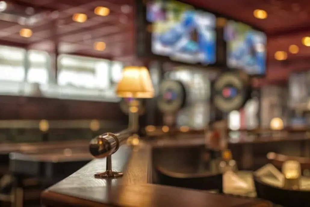 Interiør fra O'Learys i Drammen med barområde, dempet belysning og skjermer i bakgrunnen.