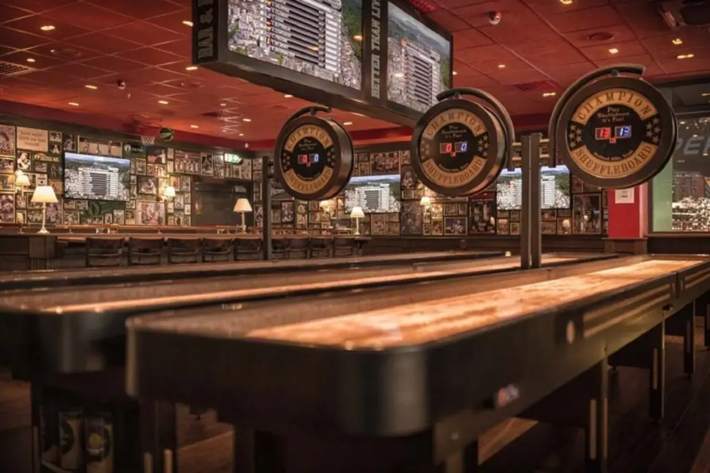 Shuffleboard-bord på O'Learys Drammen med digitale poengtavler og sportsdekor på veggene.